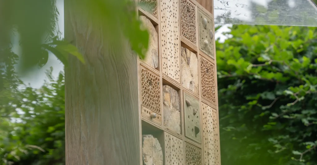 Hochwertiges Wildbienenhotel mit verschiedenen Nisthilfen in naturnaher Umgebung