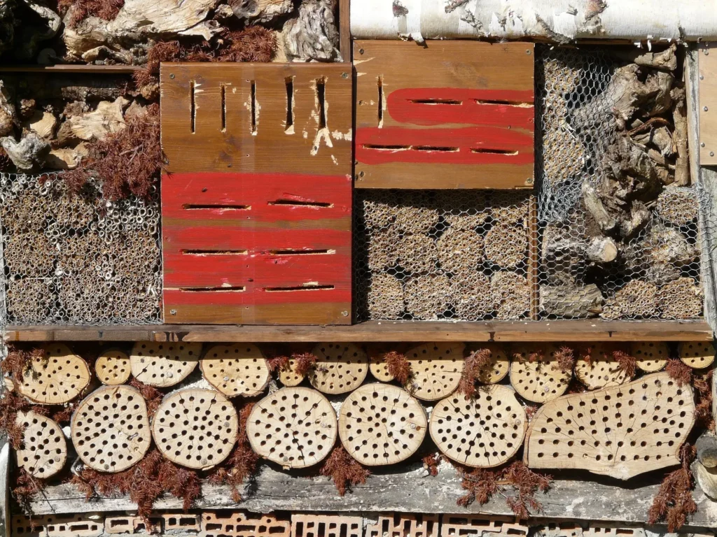 Grosses Insektenhotel mit Holzscheiben, Schlitzen, Tannenzapfen und verschiedenen Füllmaterialien